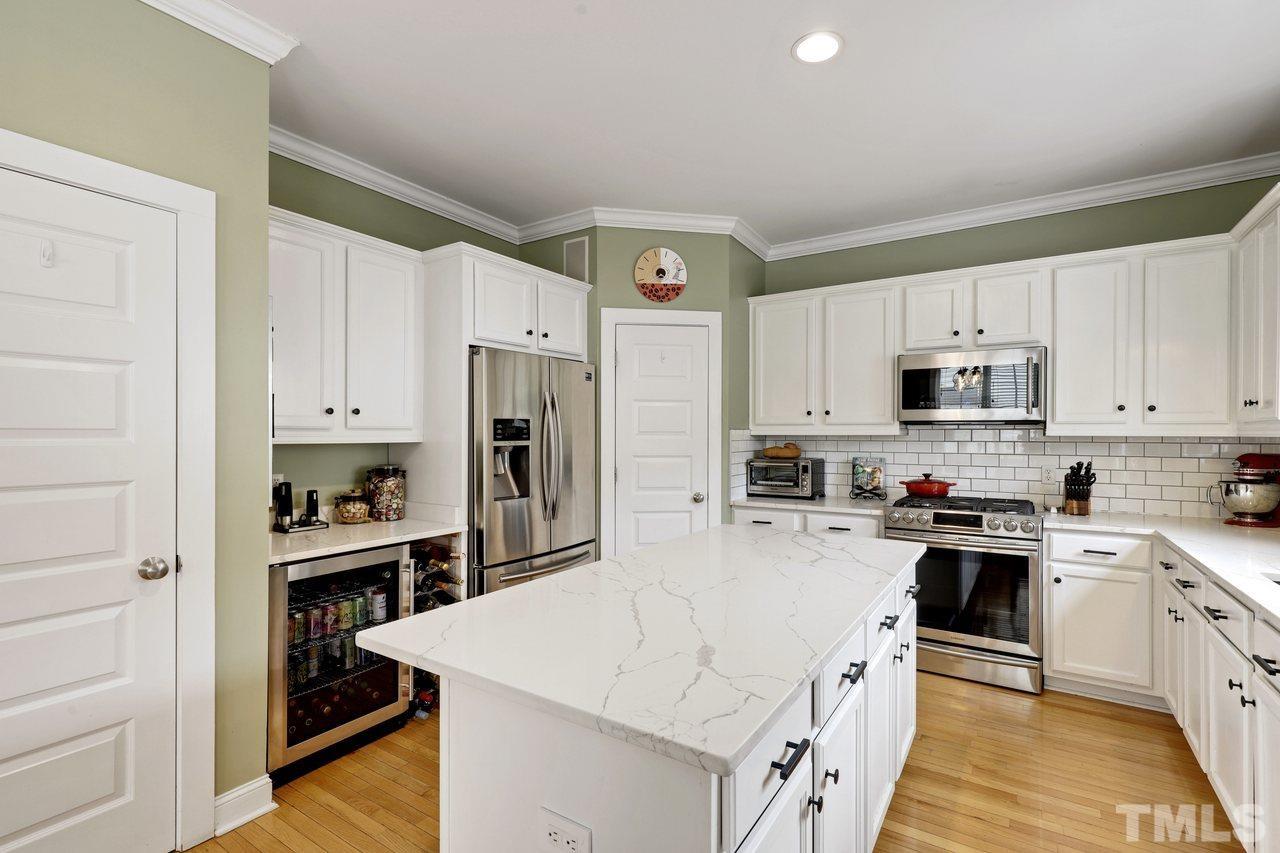 121 East Seeman Street Durham, NC 27701 - Photo 10 of 31 a kitchen with white cabinets and stainless steel appliances