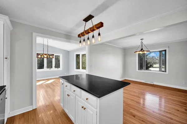 a kitchen with stainless steel appliances granite countertop a refrigerator a sink a stove and white cabinets