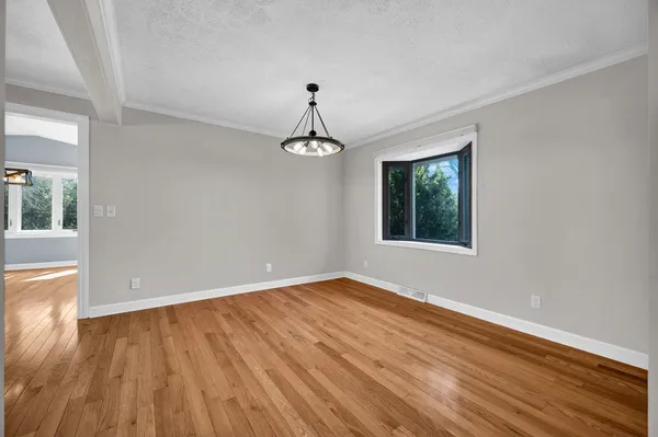 a kitchen with stainless steel appliances a sink a stove a refrigerator and white cabinets with wooden floor