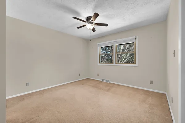 a view of a hallway with a chandelier fan and windows