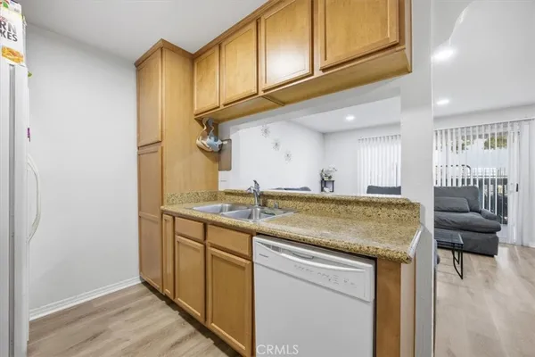 a kitchen with stainless steel appliances granite countertop a sink and a wooden cabinets