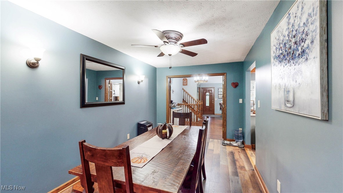 3123 Clearview Road Ravenna, OH 44266 - Photo 17 of 44 Dining area featuring wood finished floors, a chandelier, stairs, ceiling fan, and a textured ceiling