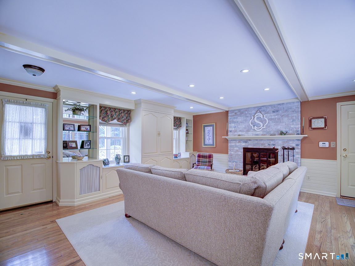 19 East Ridge Court Cheshire, CT 06410 - Photo 14 of 39 White washed brick, built in cabinets,propane fireplace, beamed ceiling.