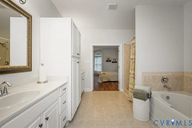 a spacious bathroom with a tub sink and mirror