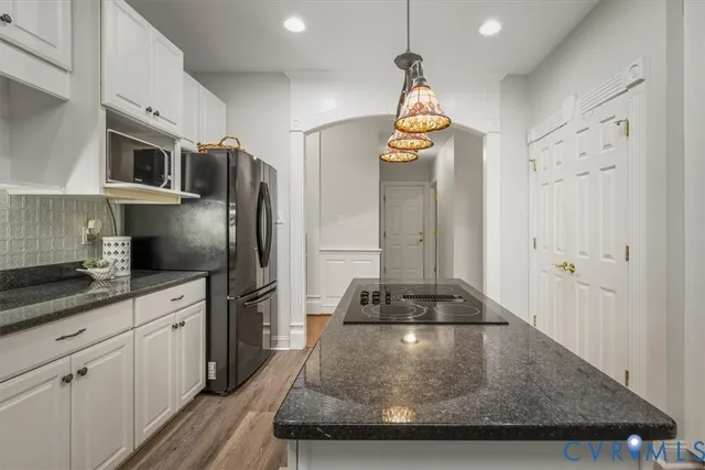 a kitchen with stainless steel appliances granite countertop a sink a stove and a refrigerator