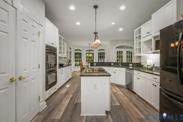 a kitchen with stainless steel appliances kitchen island granite countertop a stove a sink and a refrigerator