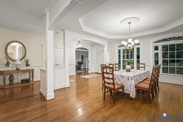 a view of a a dining room with furniture window and wooden floor