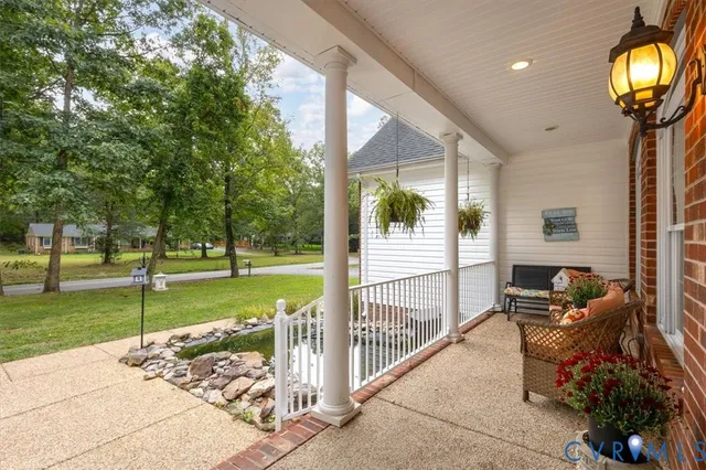 a view of a porch with couches chairs and wooden fence