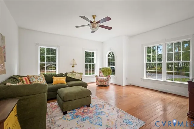 a living room with furniture and a large window with wooden floor