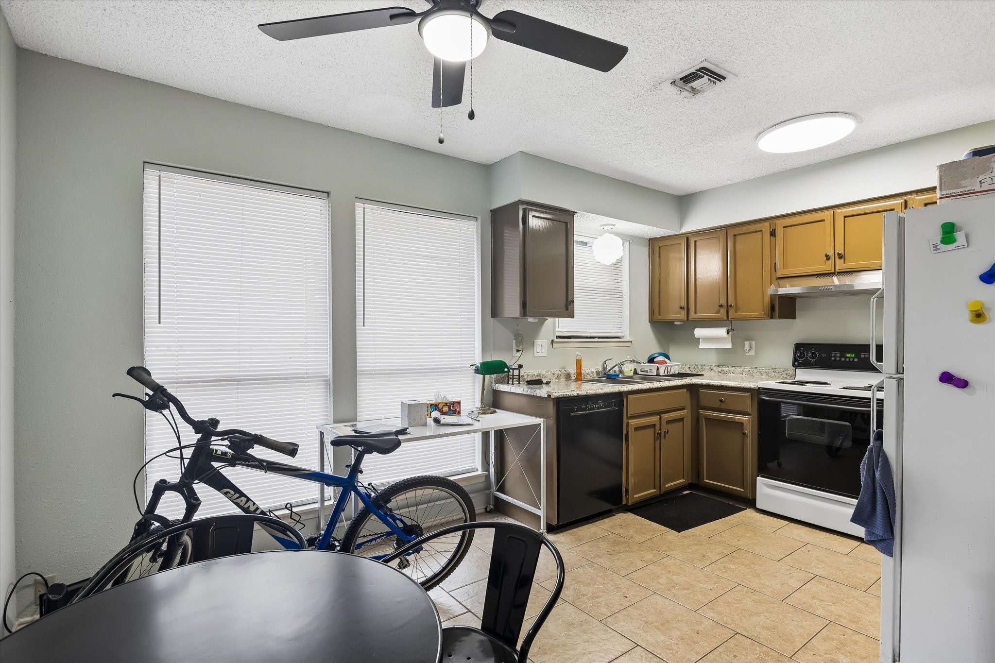 13533 George Road San Antonio, TX 78230 - Photo 15 of 34 a kitchen with stainless steel appliances granite countertop a stove top oven a sink dishwasher a dining table and chairs with wooden floor