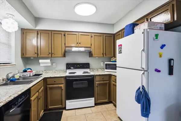 a kitchen with a white stove top oven and refrigerator