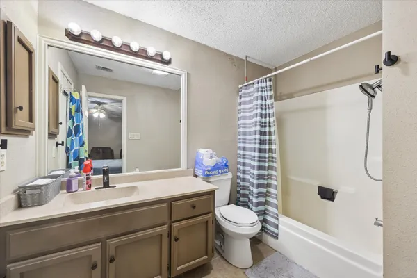 a bathroom with a sink a toilet a mirror and shower