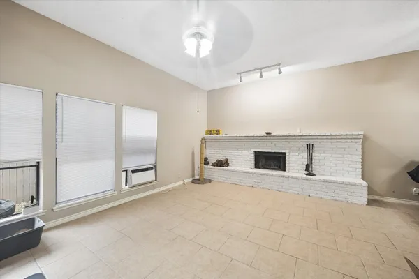 a view of an empty room with a fireplace and a window