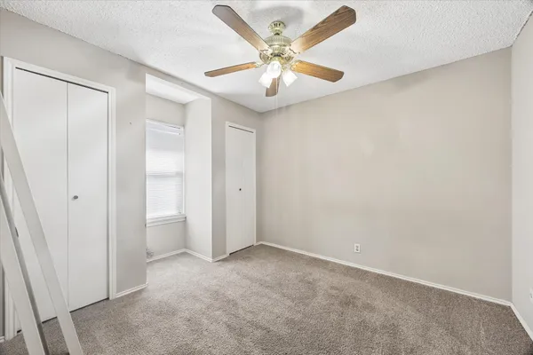 a view of a room with a ceiling fan and a shower