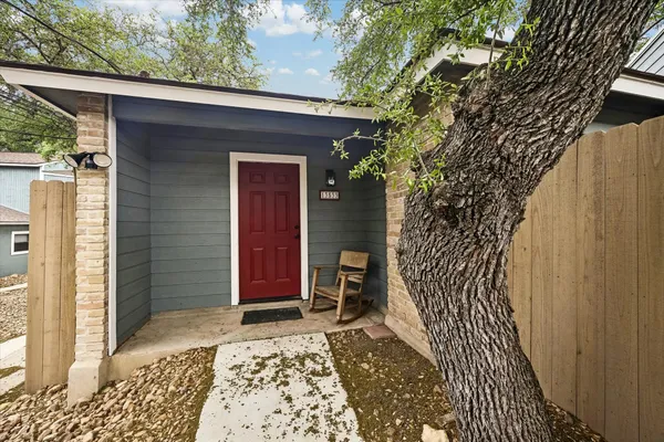 a view of a house with a door and wooden bench