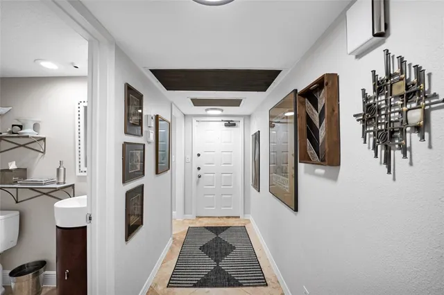 a view of a hallway with wooden floor and livingroom