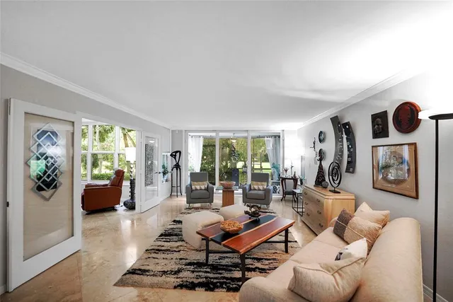 a living room with furniture potted plant and a large window