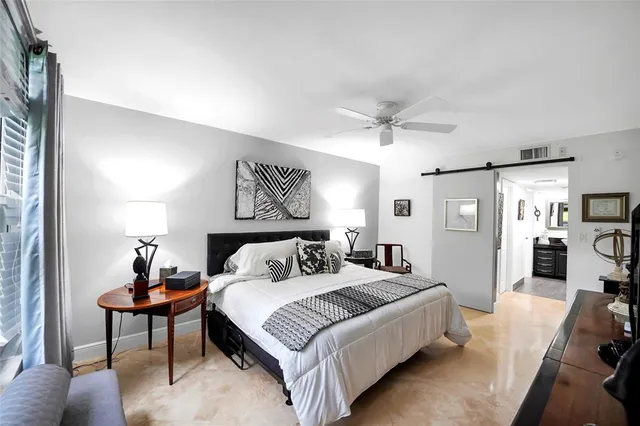 a spacious bedroom with a bed and a chandelier