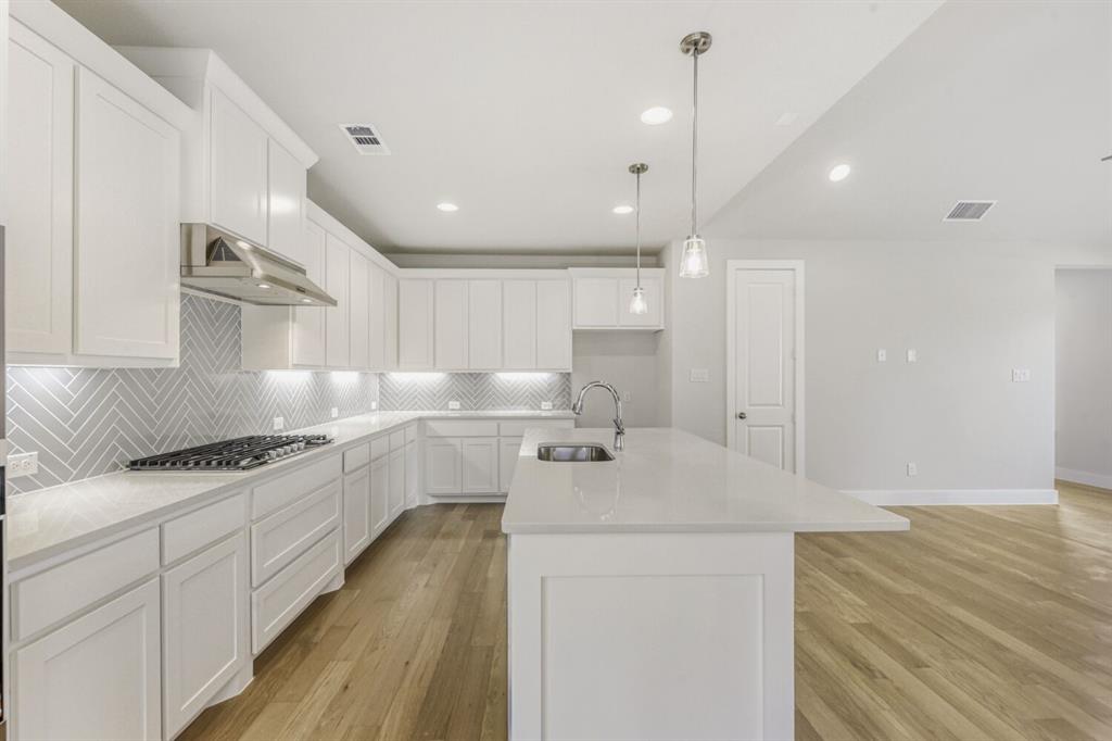 6033 Davis Knoll Road Fort Worth, TX 76126 - Photo 16 of 29 a kitchen with a sink a stove a refrigerator and white cabinets
