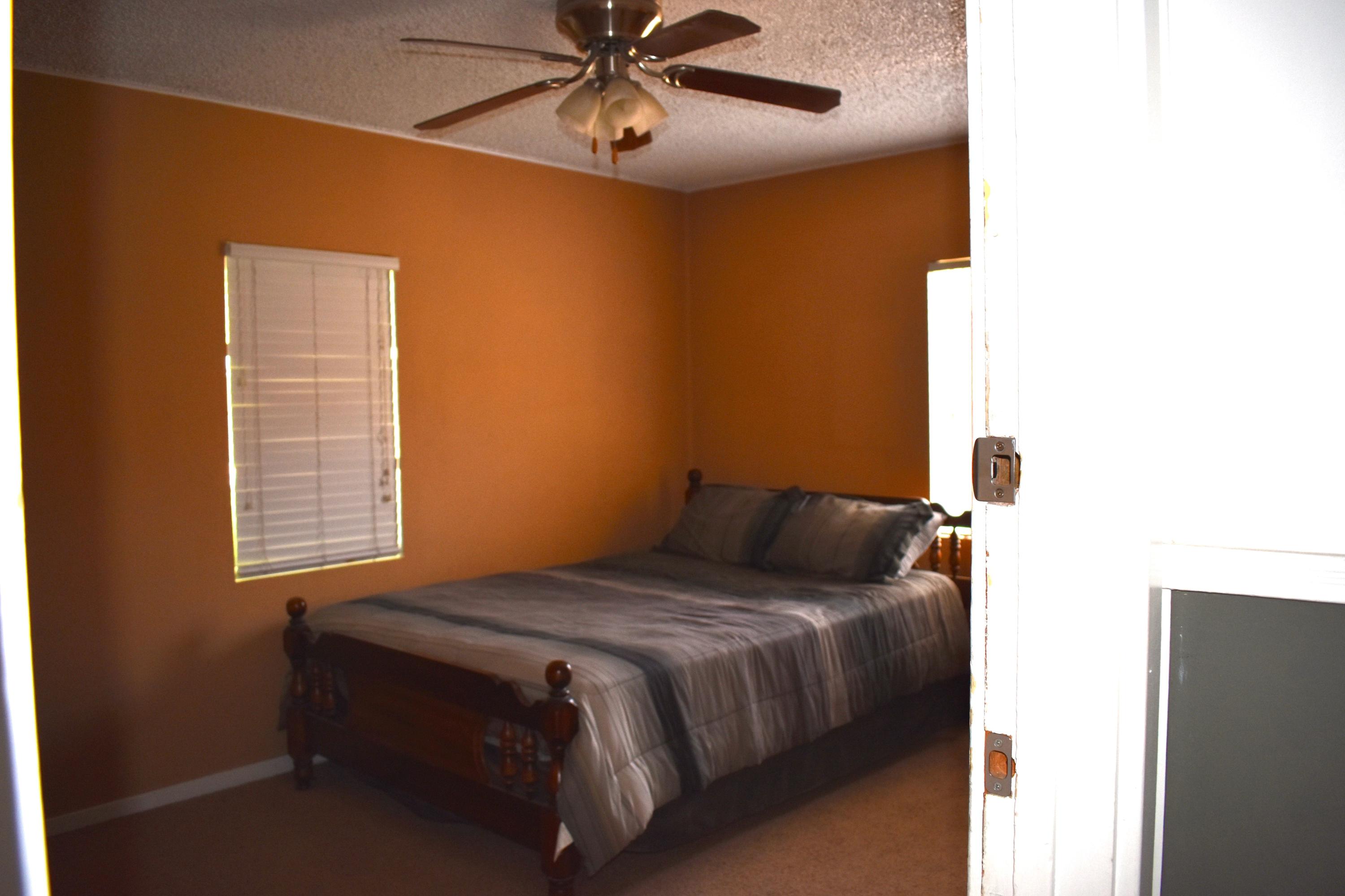 44527 Date Avenue Lancaster, CA 93534 - Photo 4 of 20 a bedroom with a bed and a chandelier