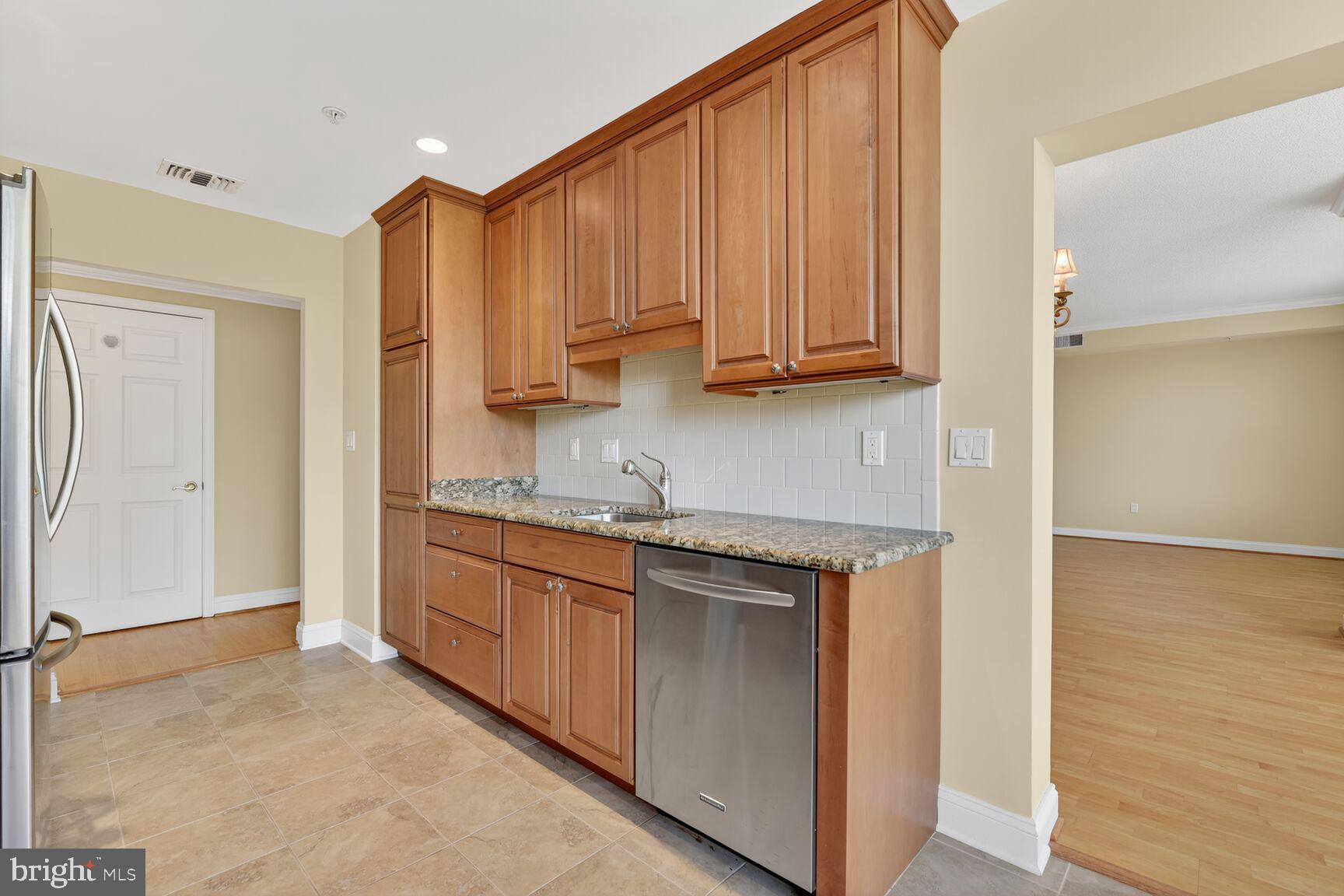 11776 Stratford House Place, Unit 507 Reston, VA 20190 - Photo 16 of 40 a kitchen with stainless steel appliances granite countertop a stove a sink and a refrigerator