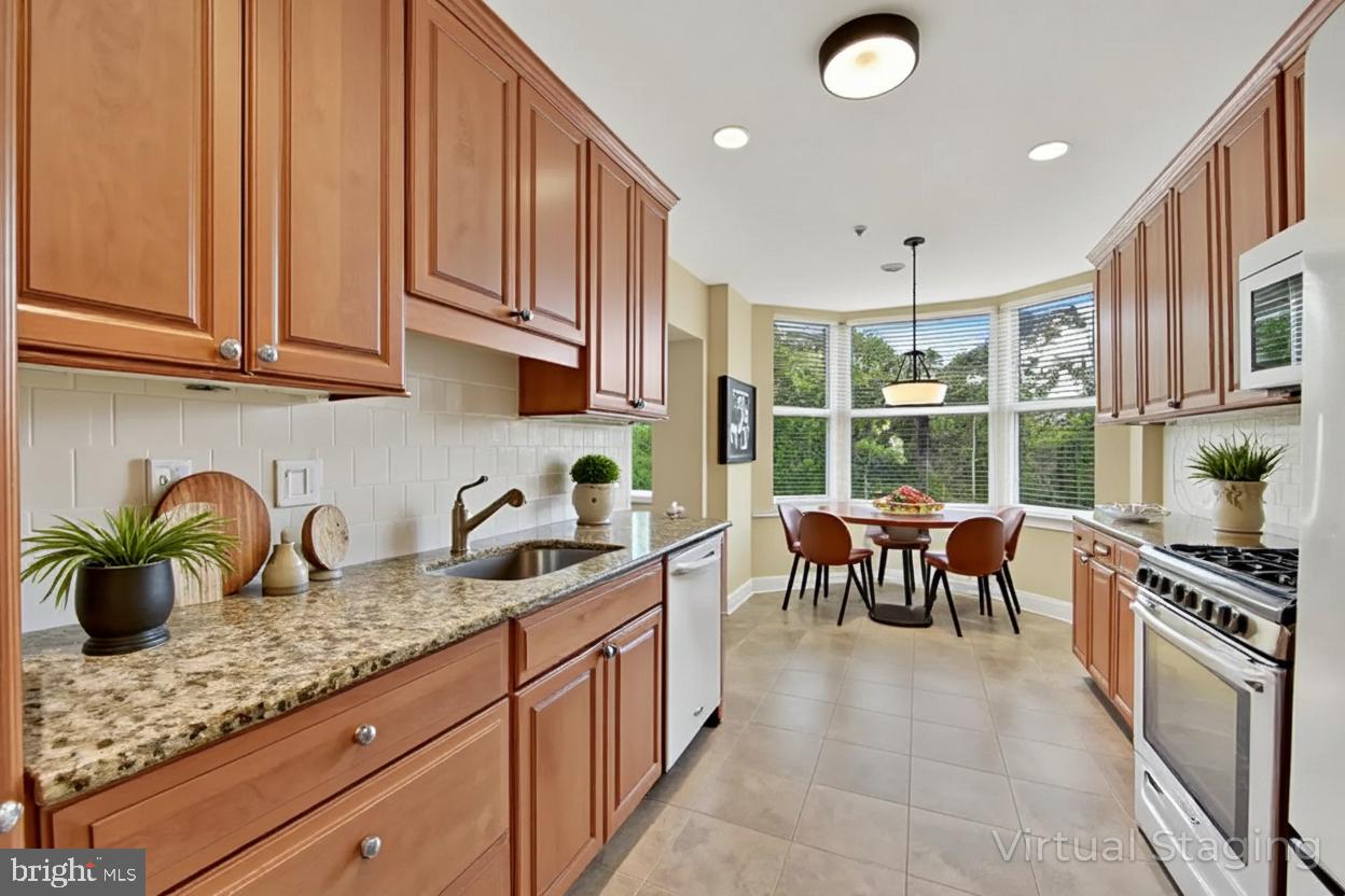 11776 Stratford House Place, Unit 507 Reston, VA 20190 - Photo 5 of 40 a kitchen with granite countertop a sink and a stove