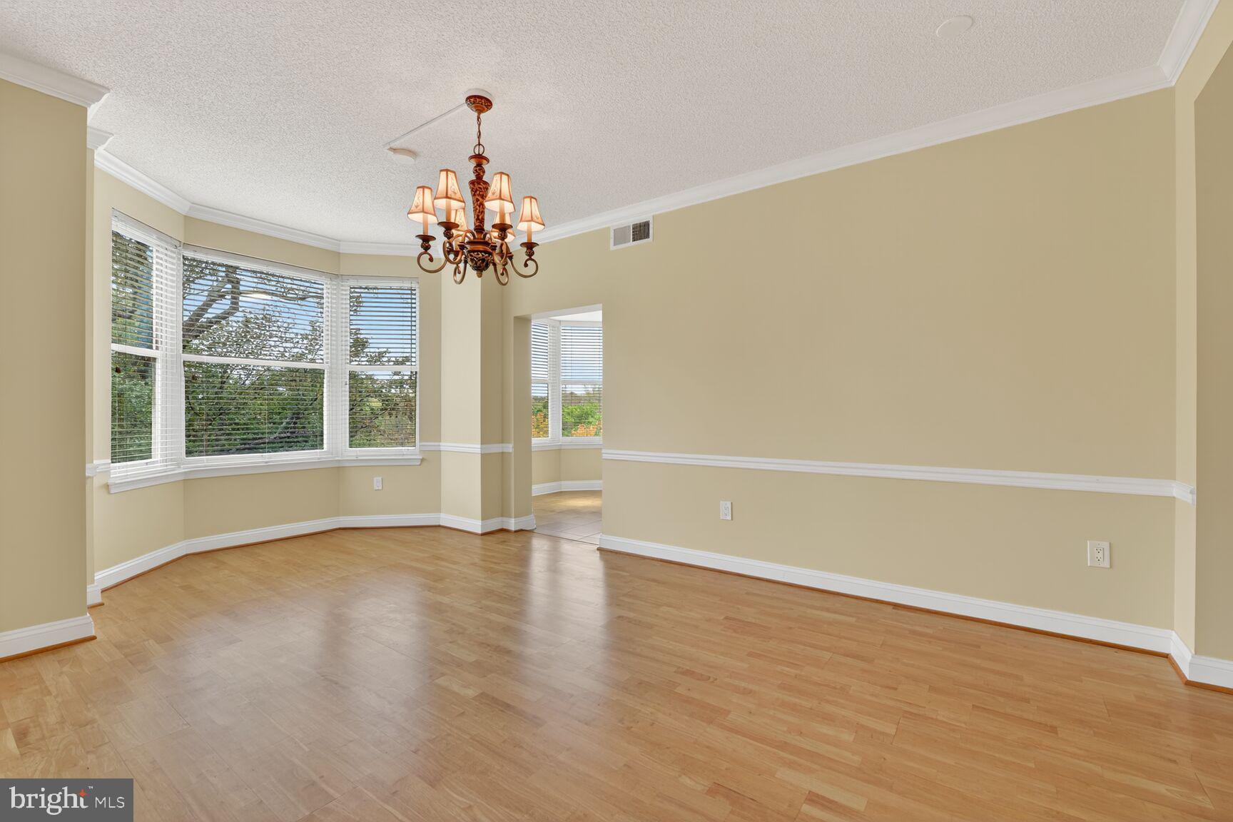 11776 Stratford House Place, Unit 507 Reston, VA 20190 - Photo 10 of 40 a view of a room with wooden floor large windows and a chandelier