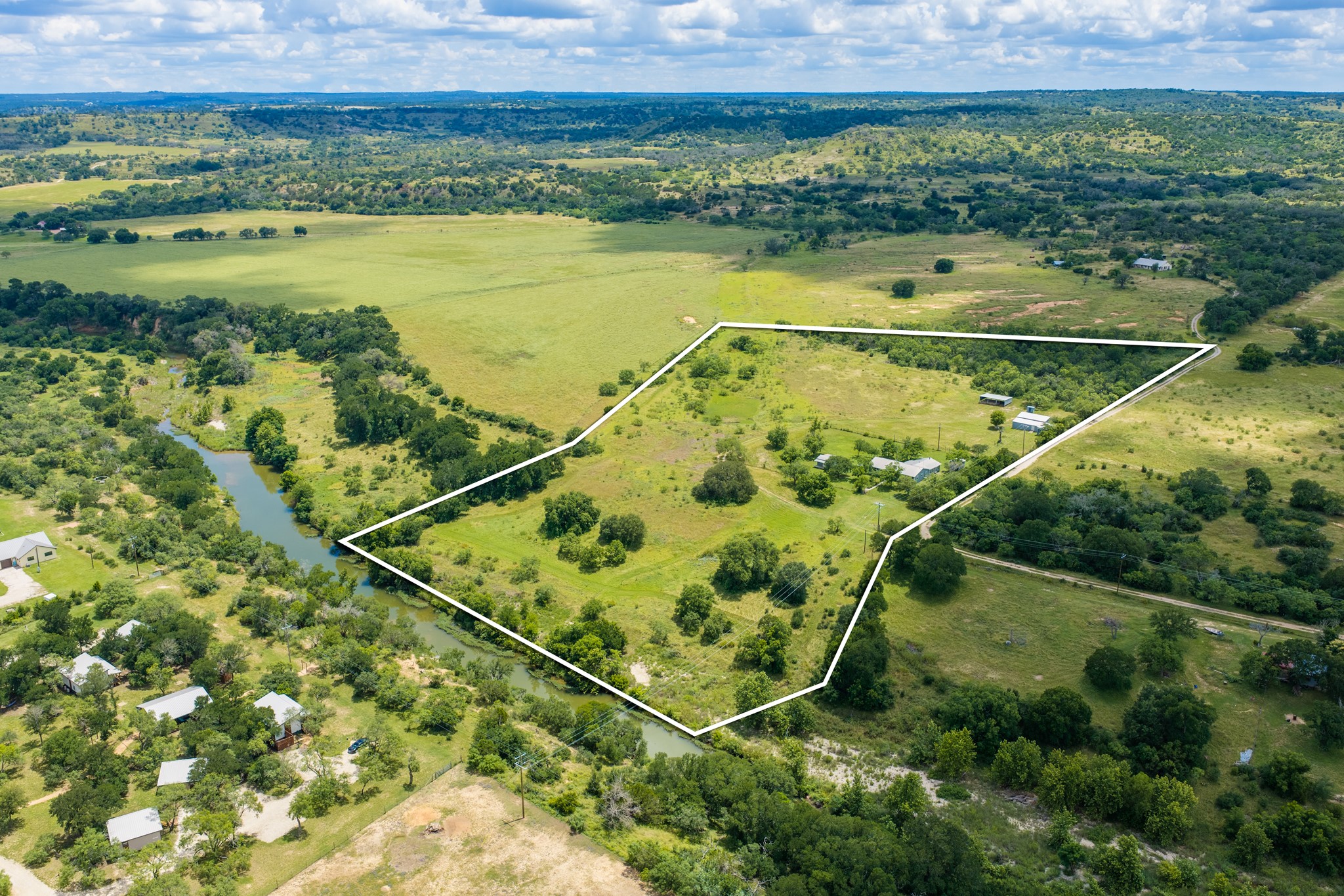 341 River View Road Fredericksburg, TX 78624 - Photo 1 of 40 Lush rolling hills and a winding creek outline this sprawling countryside acreage.