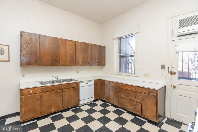 a kitchen with a sink a stove cabinets and window