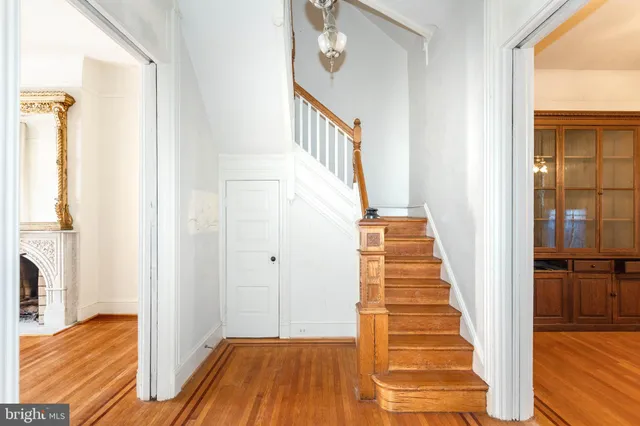 a view of a hallway with wooden floor and staircase
