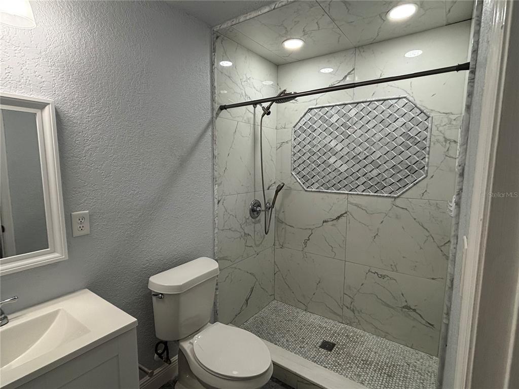 7185 Holiday Drive Spring Hill, FL 34606 - Photo 15 of 25 a bathroom with a shower toilet and sink