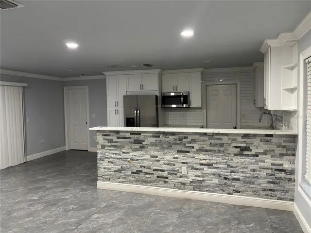a view of kitchen with granite countertop cabinets