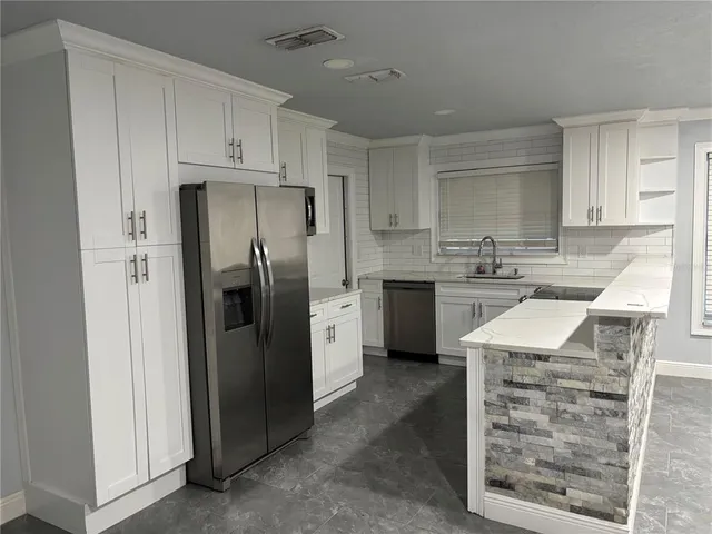 a kitchen with stainless steel appliances granite countertop a refrigerator sink and cabinets
