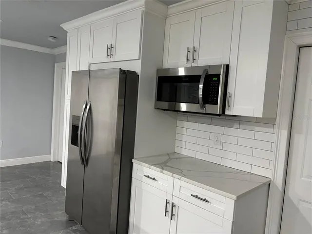 a kitchen with stainless steel appliances white cabinets and a refrigerator