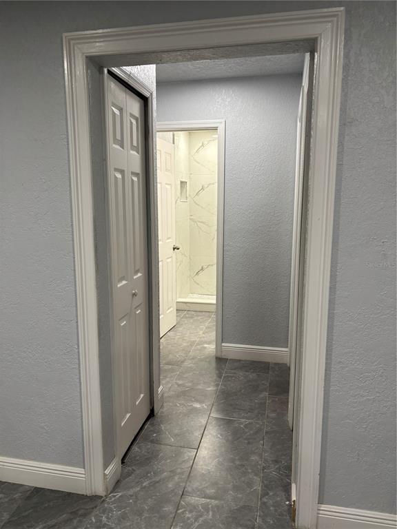 7185 Holiday Drive Spring Hill, FL 34606 - Photo 10 of 25 a view of a hallway with a glass door and a bathroom in closet