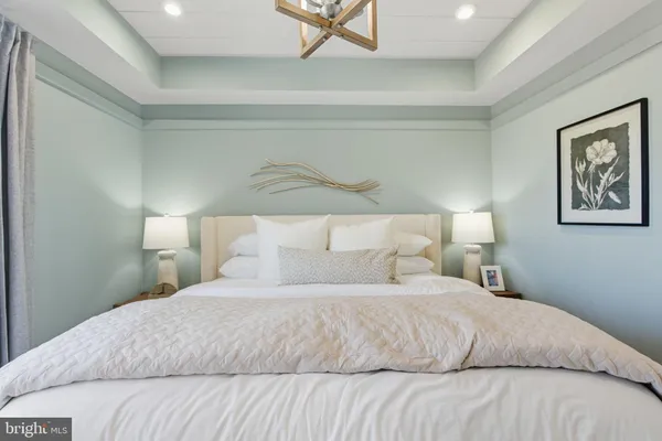 a bedroom with a bed and painting on the wall