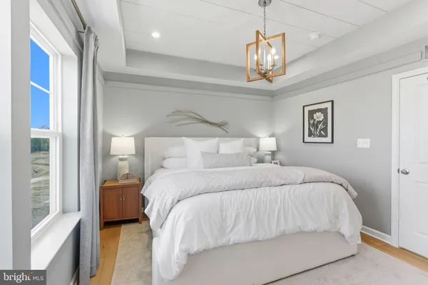 a bedroom with a large bed and a chandelier