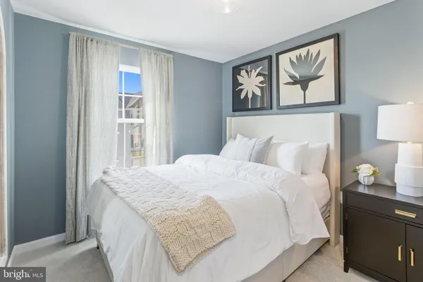 a bedroom with a bed and painting on the wall