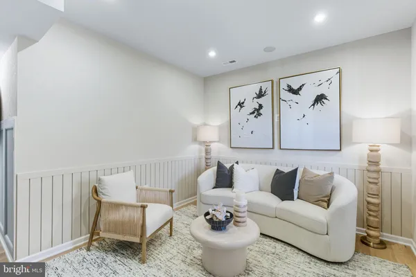 a living room with furniture and wall paintings