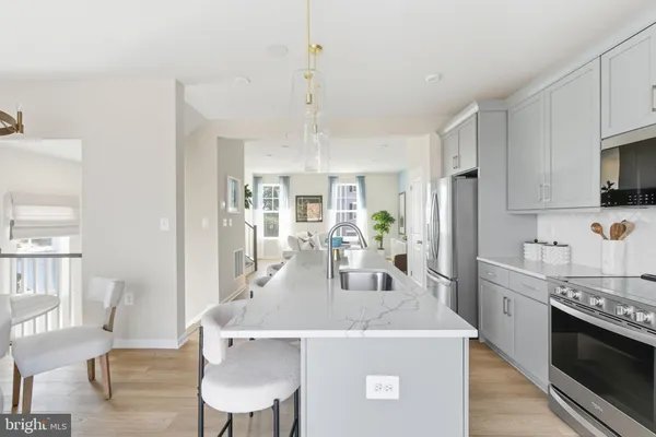 a kitchen with kitchen island a stove a table a sink refrigerator and cabinets