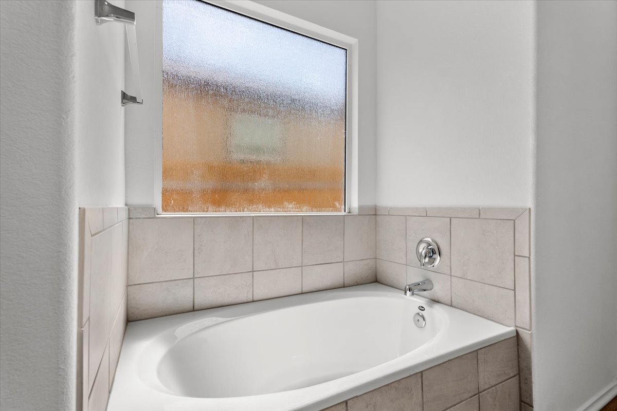 448 Perfect World Loop Jarrell, TX 76537 - Photo 30 of 40 An inviting tub, ideal for relaxation, sits beneath a private frosted window.