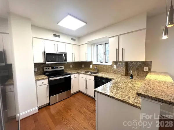 a kitchen with a sink a stove and microwave