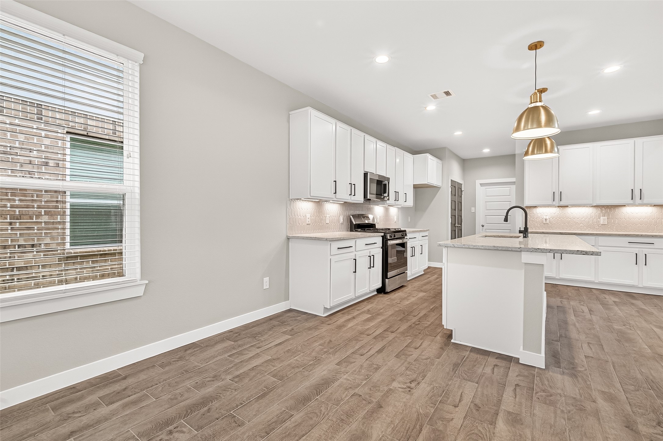 2142 Reed Cave Lane Spring, TX 77386 - Photo 21 of 50 a kitchen with stainless steel appliances granite countertop a sink a stove a refrigerator cabinets and a window
