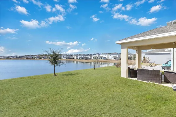 a view of a house with a yard and lake view