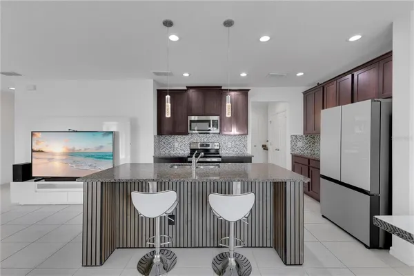 a kitchen with refrigerator and chairs