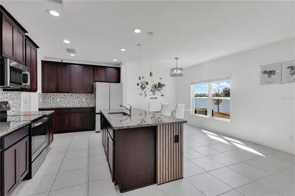 a kitchen with kitchen island granite countertop a sink and a stove top oven with granite countertops