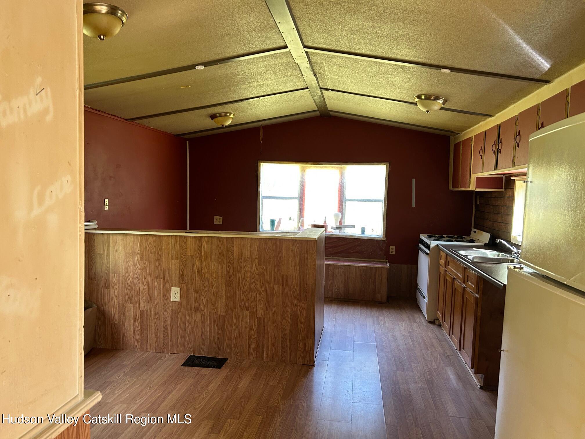 26 Iken Road Kerhonkson, NY 12446 - Photo 4 of 7 a kitchen with stainless steel appliances granite countertop a refrigerator a sink dishwasher a stove and white countertops with wooden floor