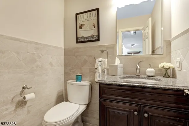 a bathroom with a granite countertop toilet sink and mirror