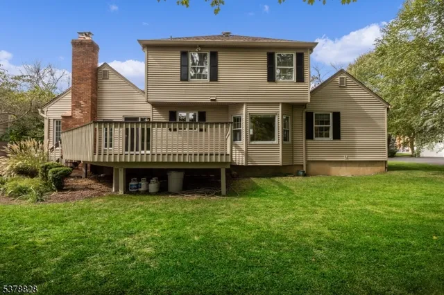 a view of a house with a wooden deck and a yard