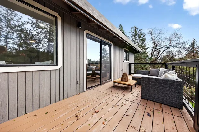 a backyard of a house with wooden floor and outdoor seating